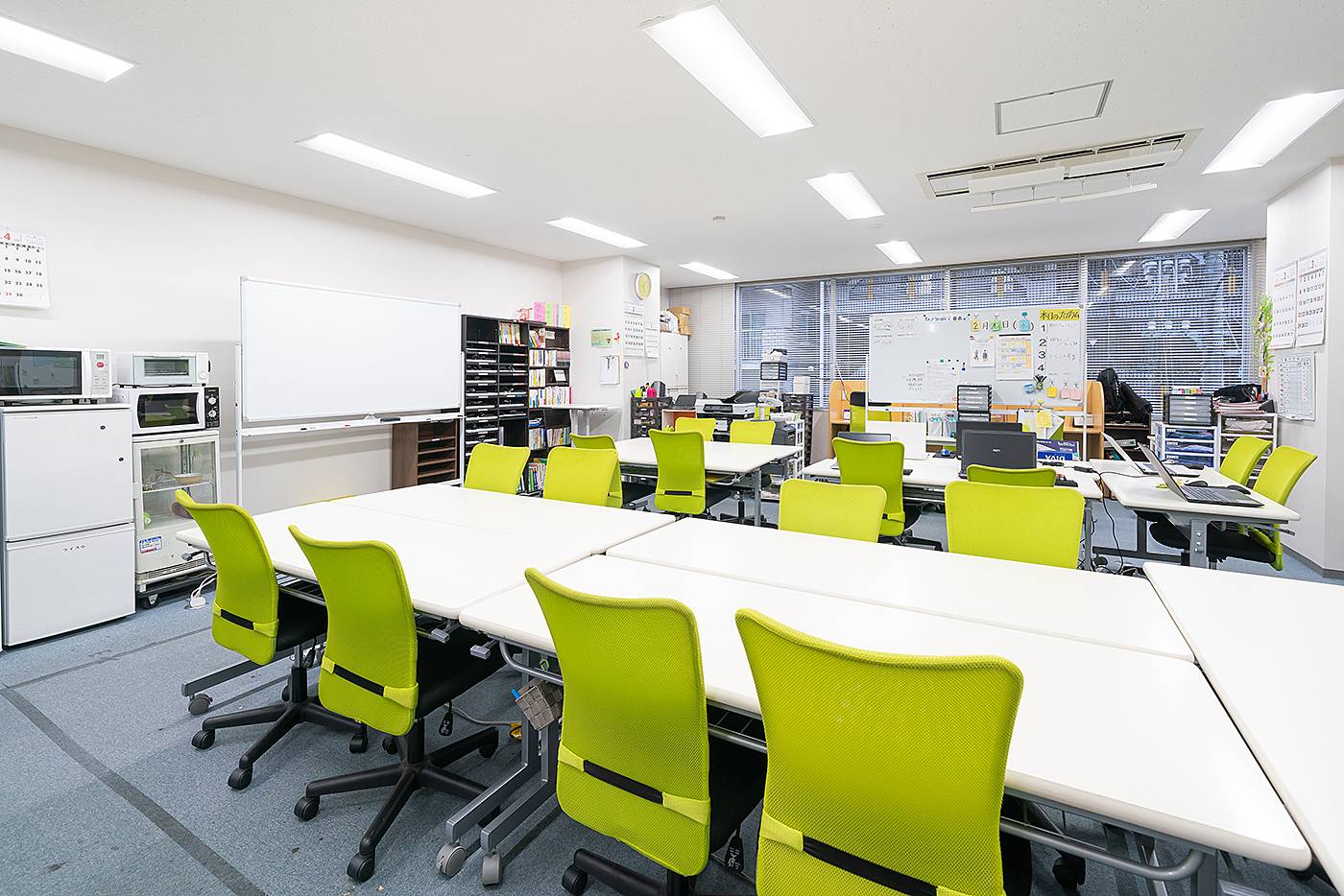 アイ・ワークス西明石の事業所内の様子。明るい机と椅子が並ぶ作業スペース