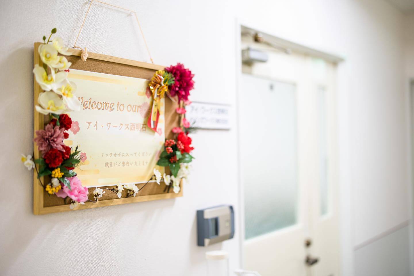 アイ・ワークス西明石の事業所入口に設置された案内プレートの写真