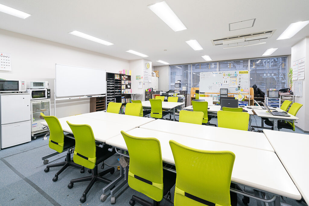 アイ・ワークス西明石の事業所内の様子。明るい机と椅子が並ぶ作業スペース